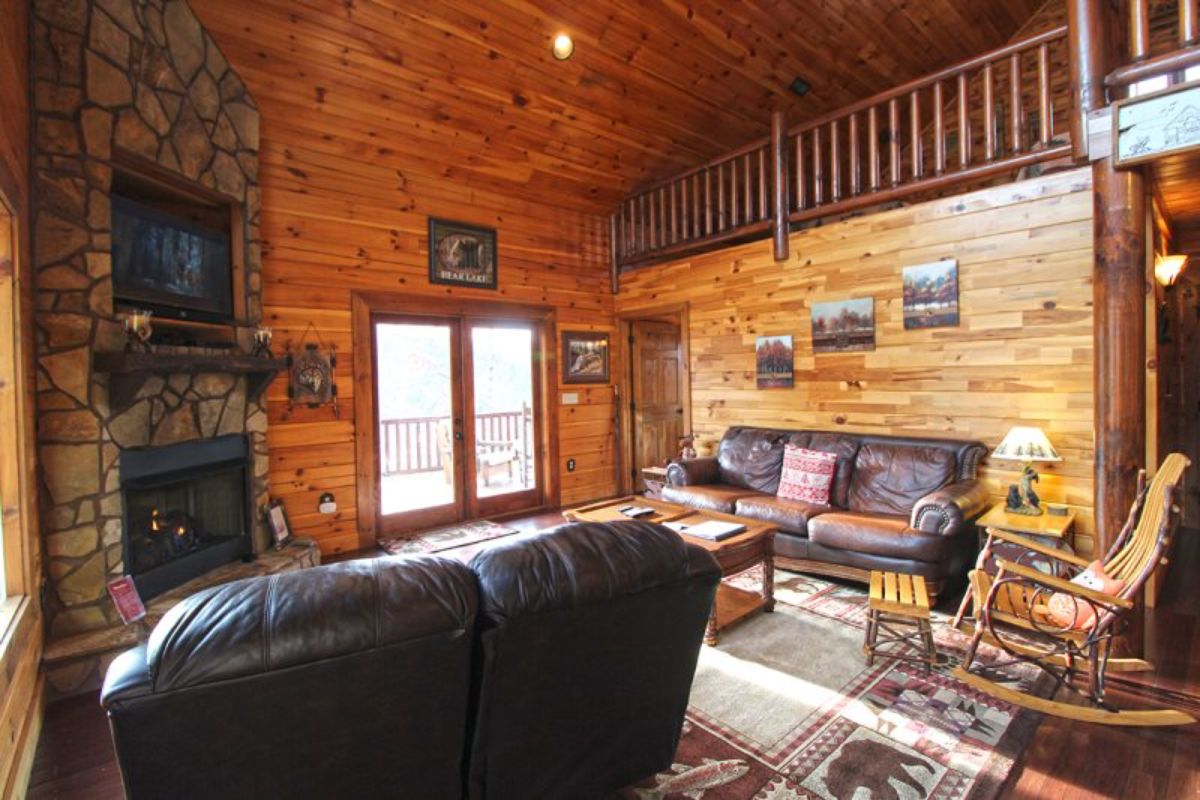 black leather sofa in foreground with loft above