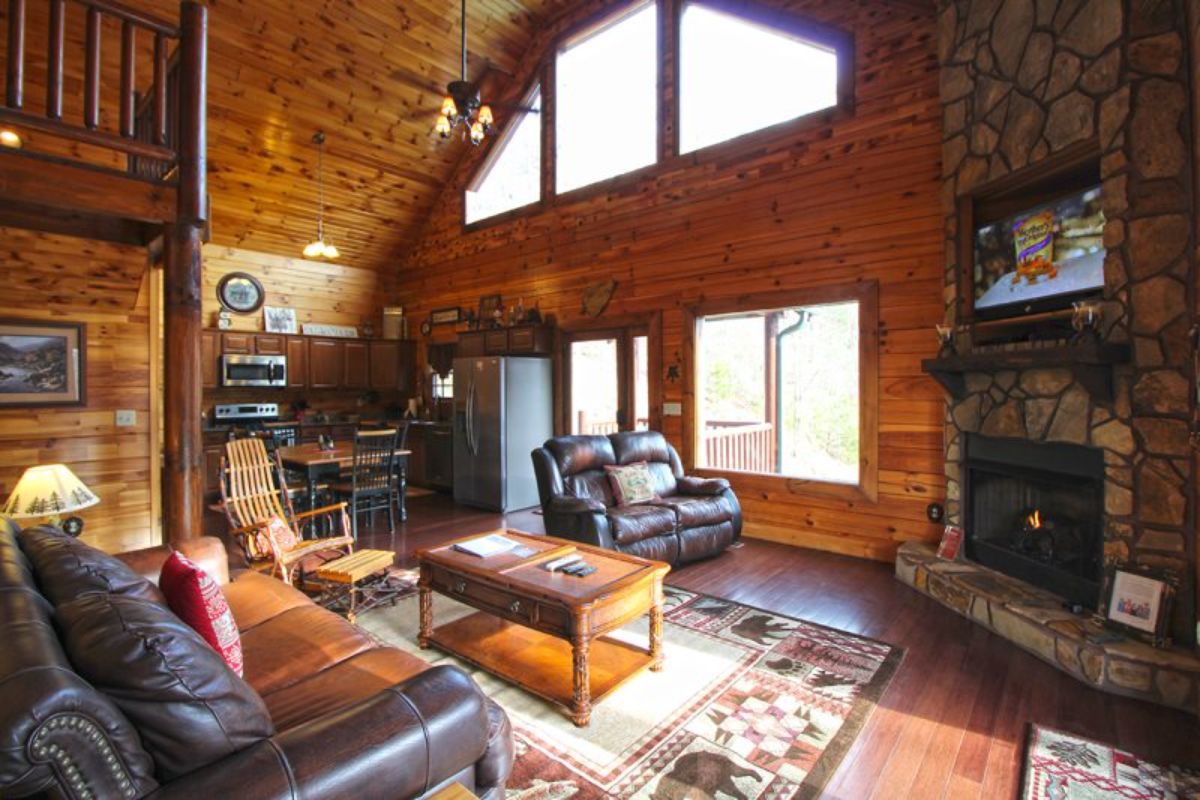 sofa by large windows with wood coffee table on white rug