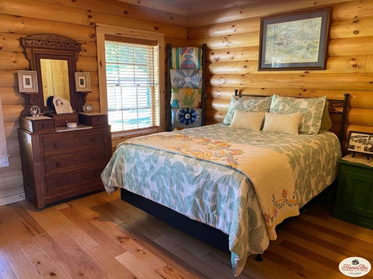 floral bedding on bed against log wall
