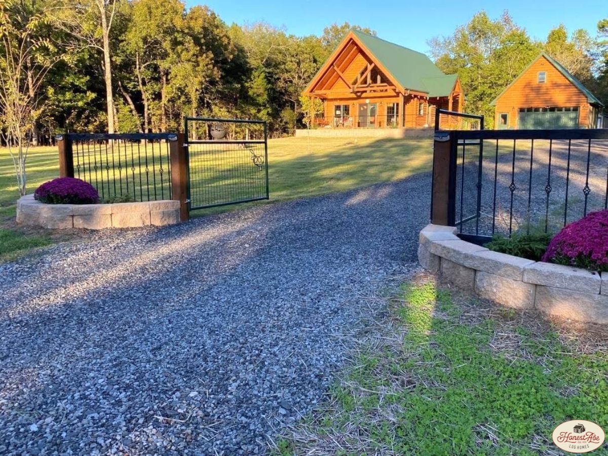 gravel drive leading to cabin behind gates