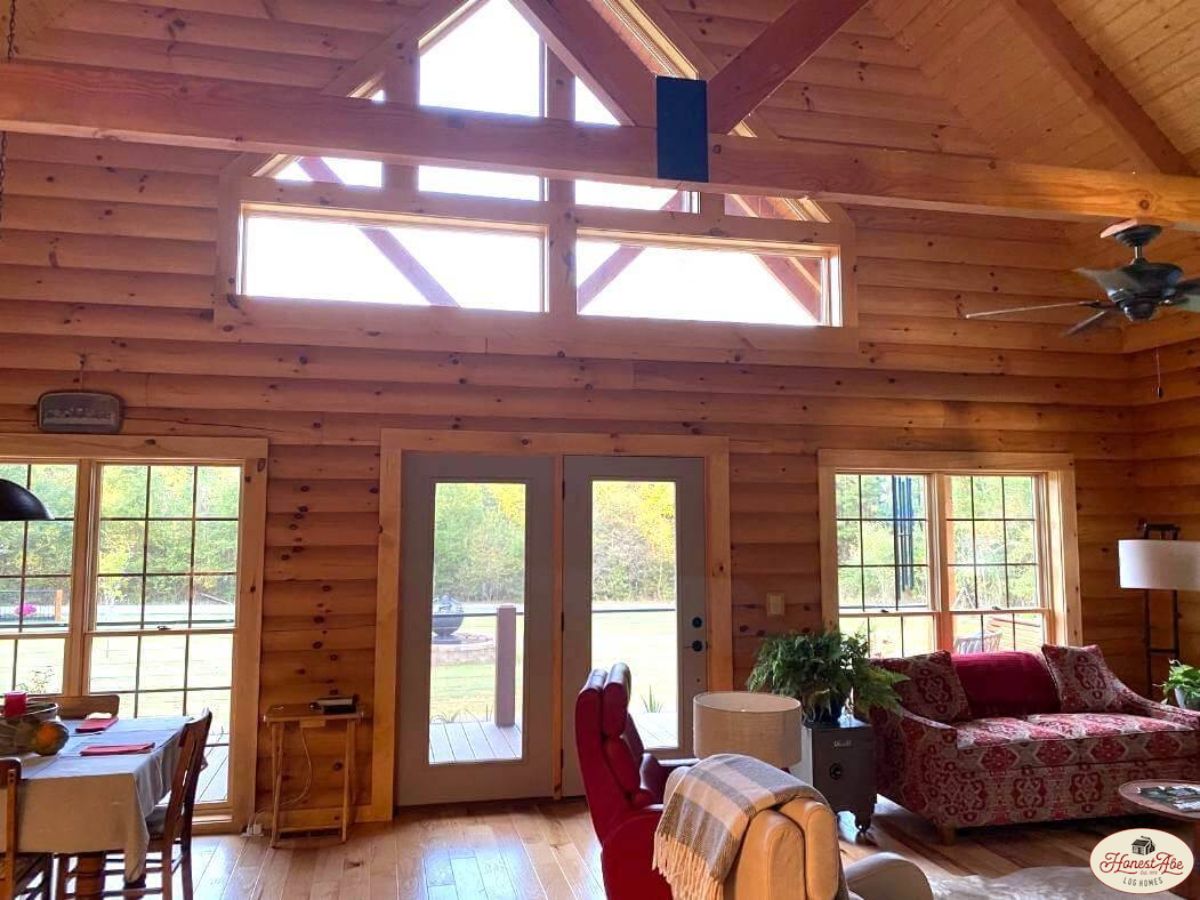 light wood log walls in cabin with red sofa on right