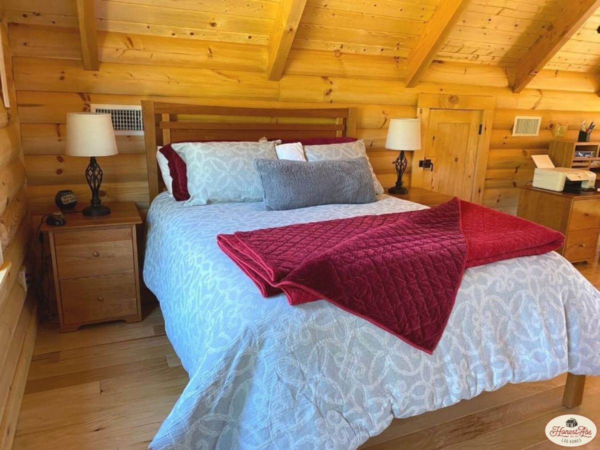 white bedding on sleigh bed in log cabin loft