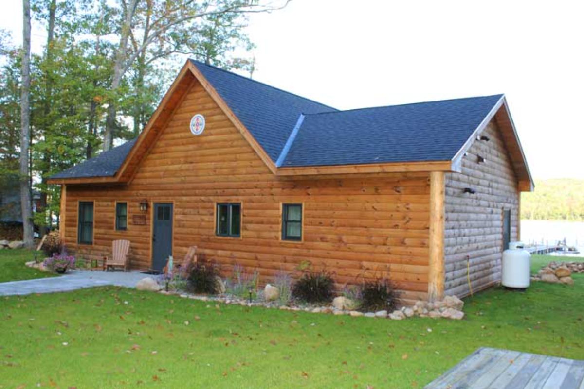 log cabin front with gray door at small walkway