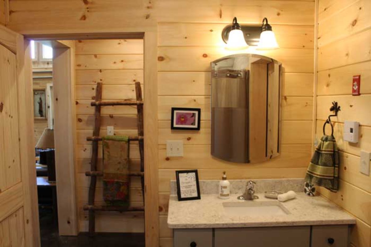 wood ladder visible through door by vanity