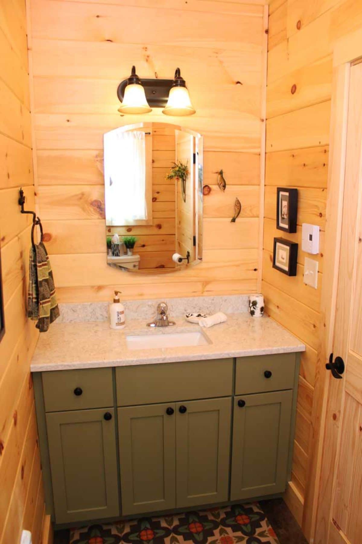 light green vanity below white counter and sink with large mirror on wall