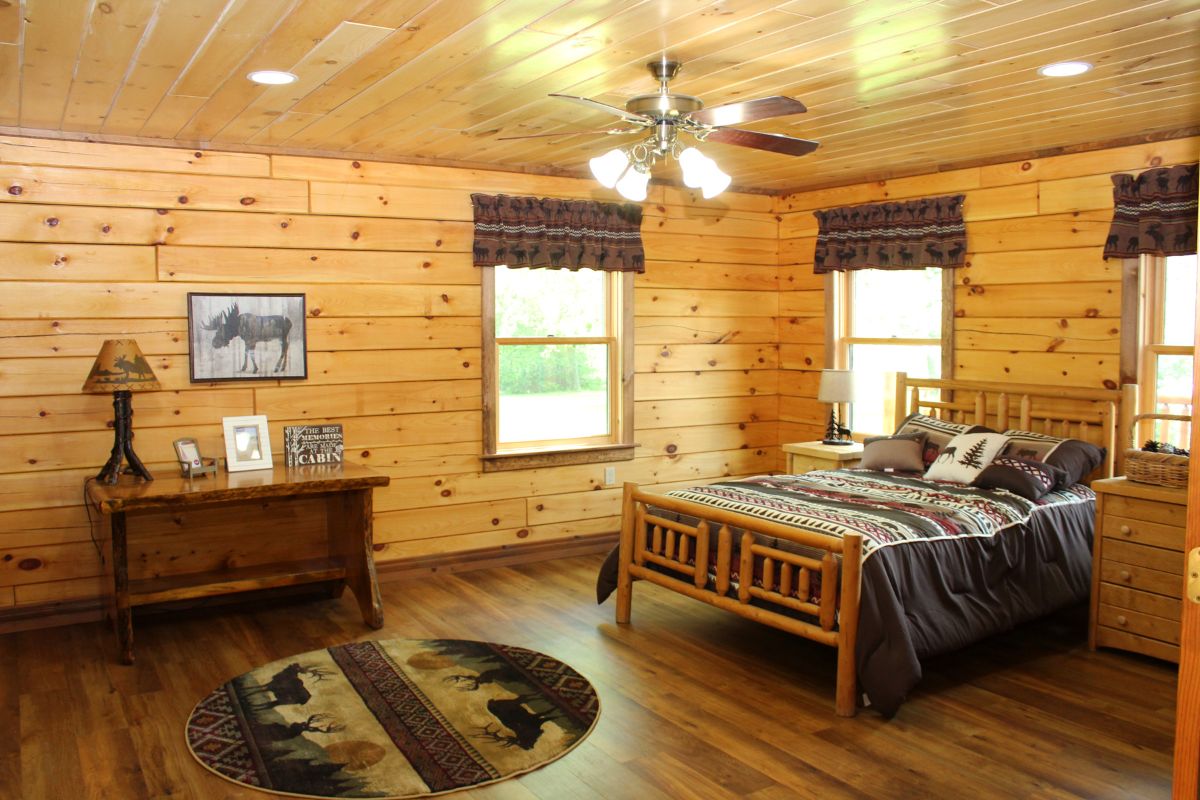 wood frame bed against right wall with round rustic rug in foreground