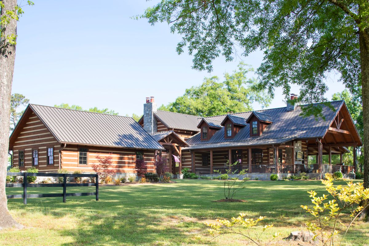 back porch of log cabin with chimney between buildings