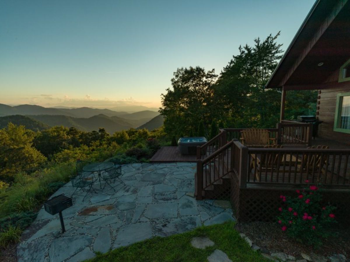 view of patio area off the side of log cabin overlooking mountains