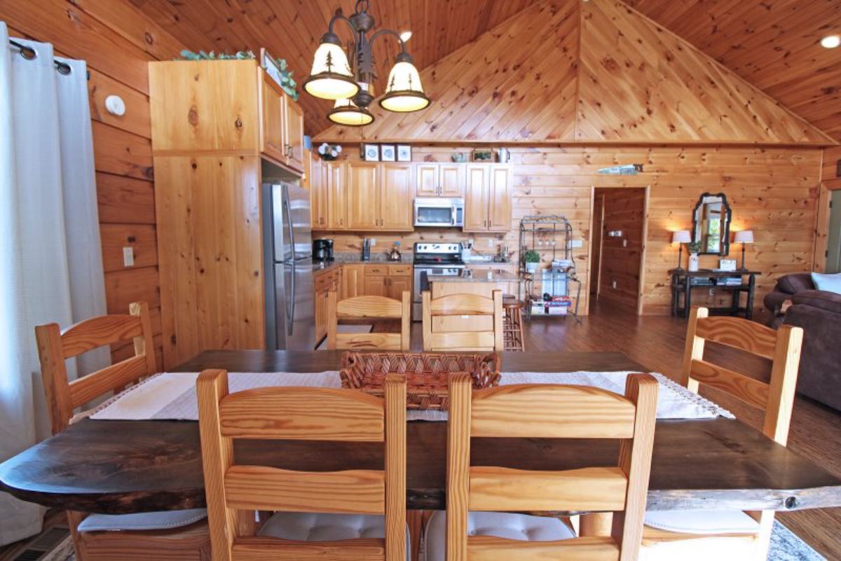 view across table into log cabin kitchen