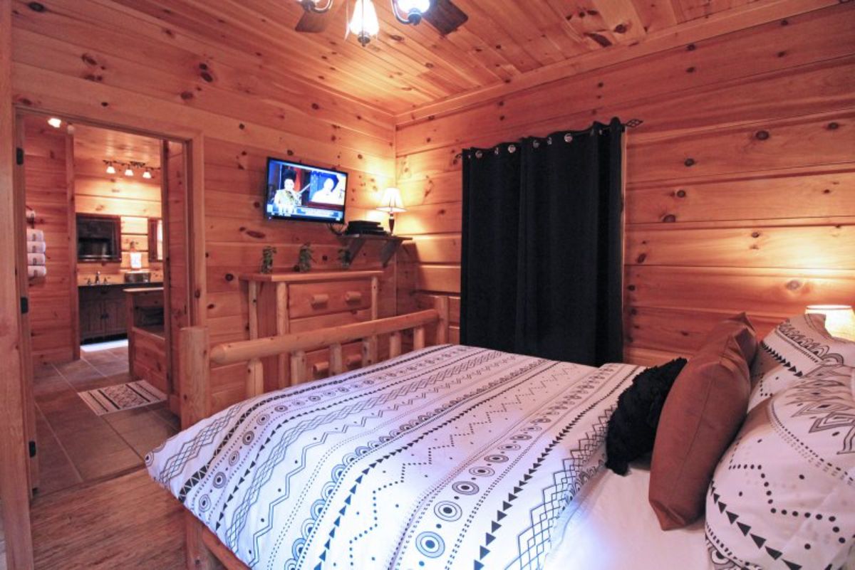 TV mounted on wall across from bed in cabin