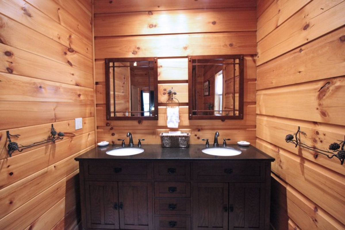 dark wood vanity with white sinks on either side