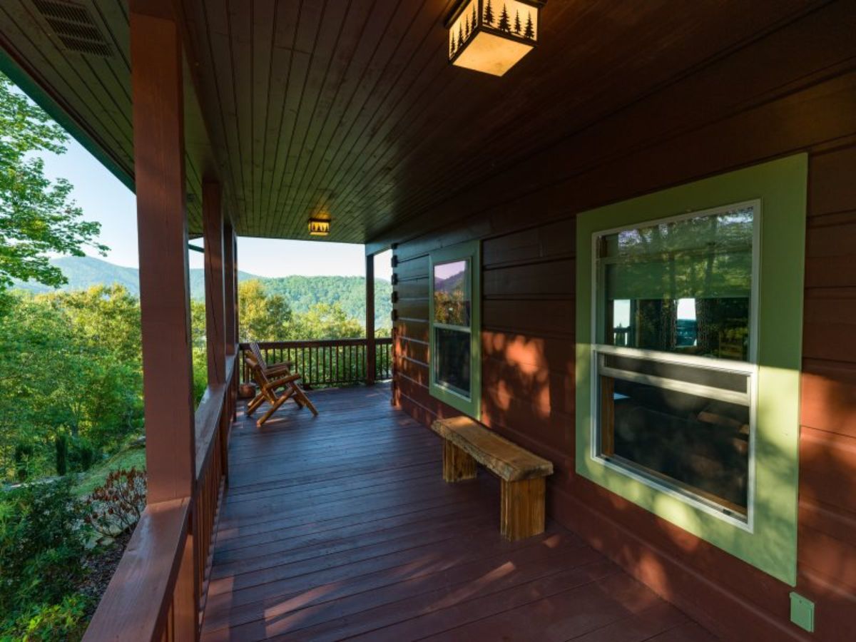 white trim around windows on porch of cabin with bench between windows