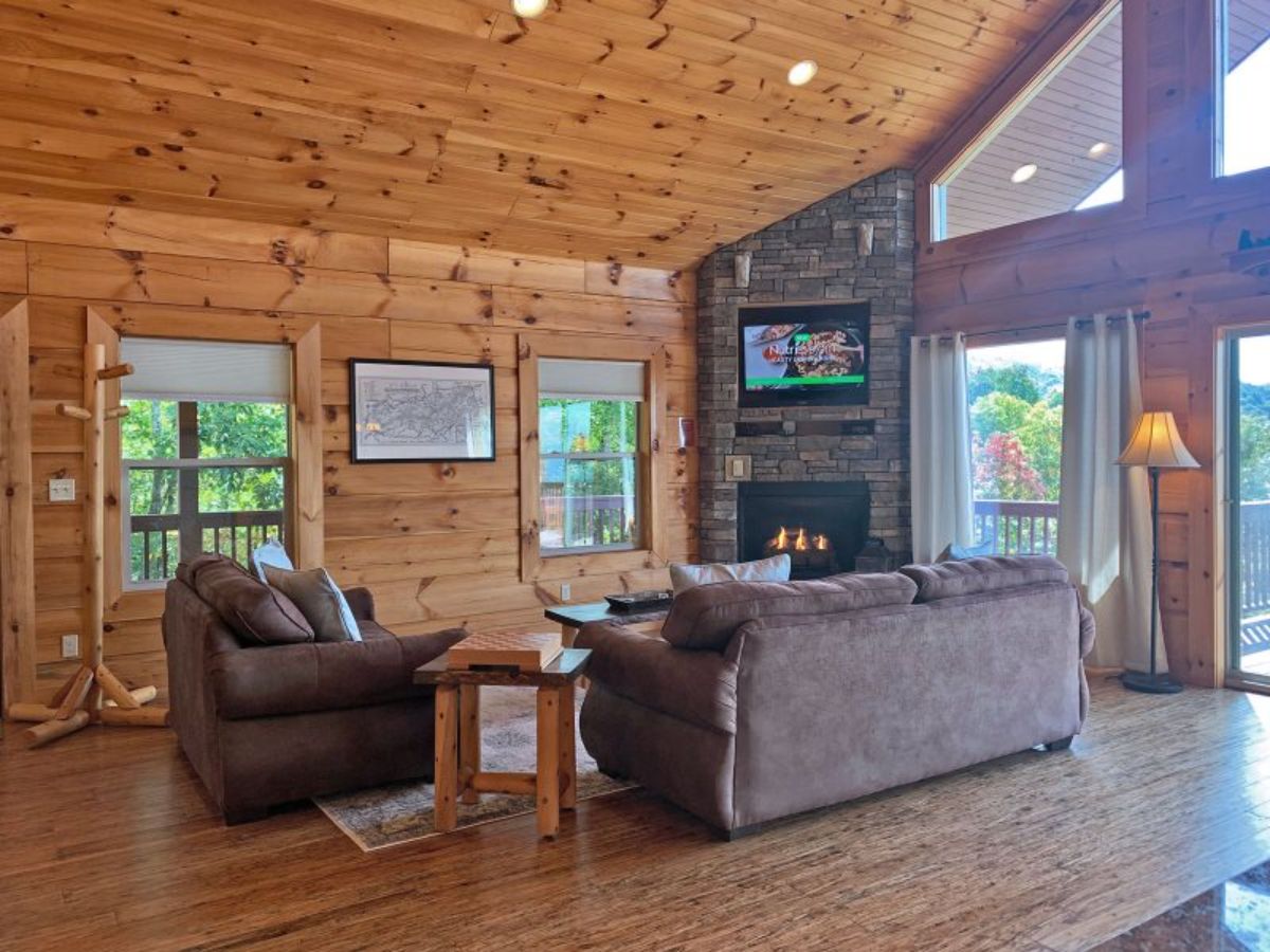 view across front of living space with window against light wood walls