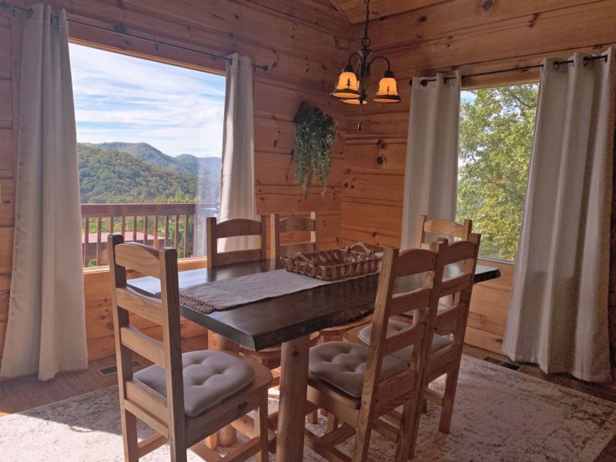 dining table beneath lantern with windows on both sides