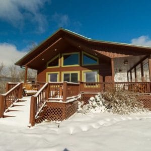 front of log cabin in snow
