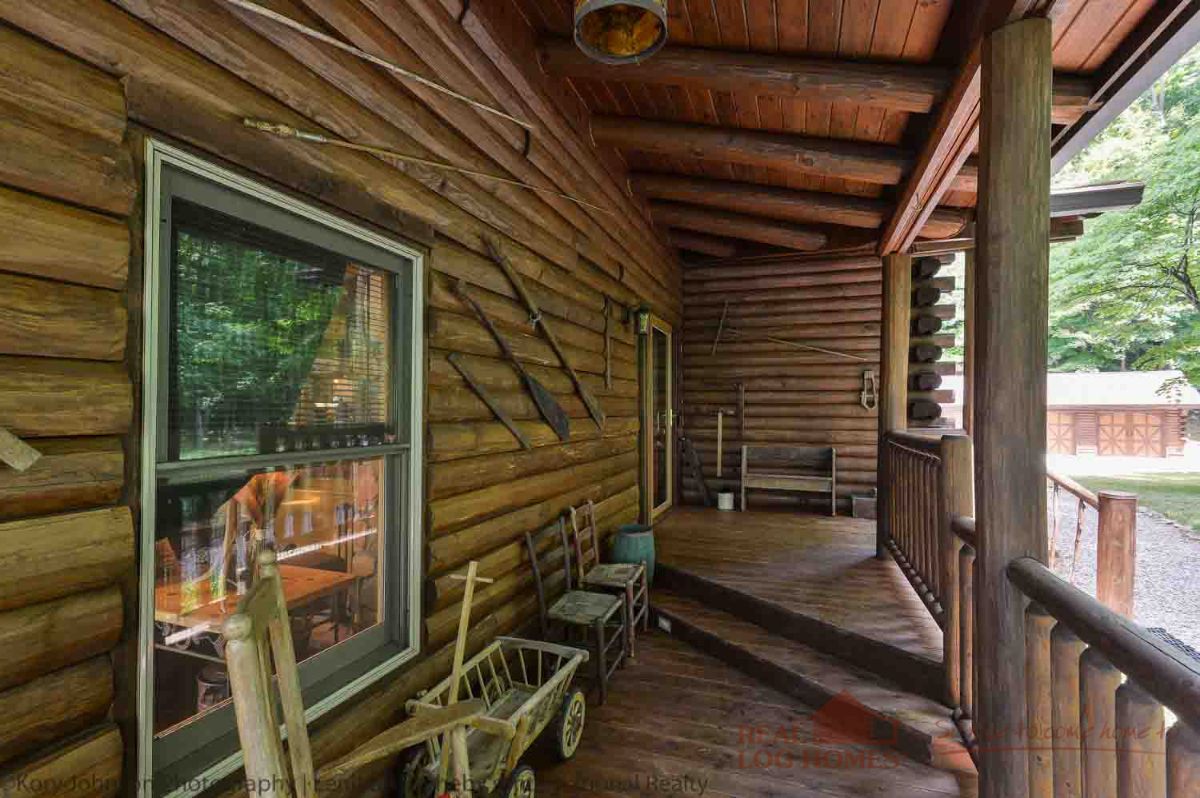 log cabin covered porch with rocking chair and elevated steps to door