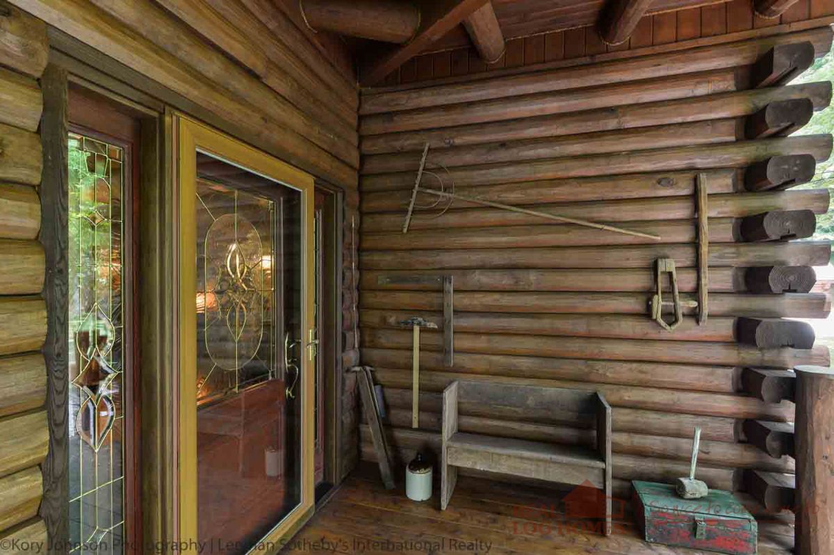 wooden bench against wall by front door to log cabin