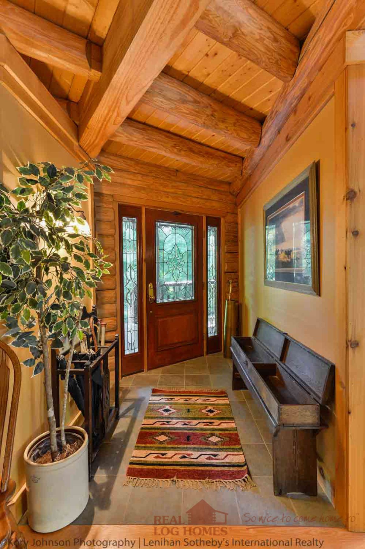 dark wood door against light wood walls in cabin entry with bench seat on right side