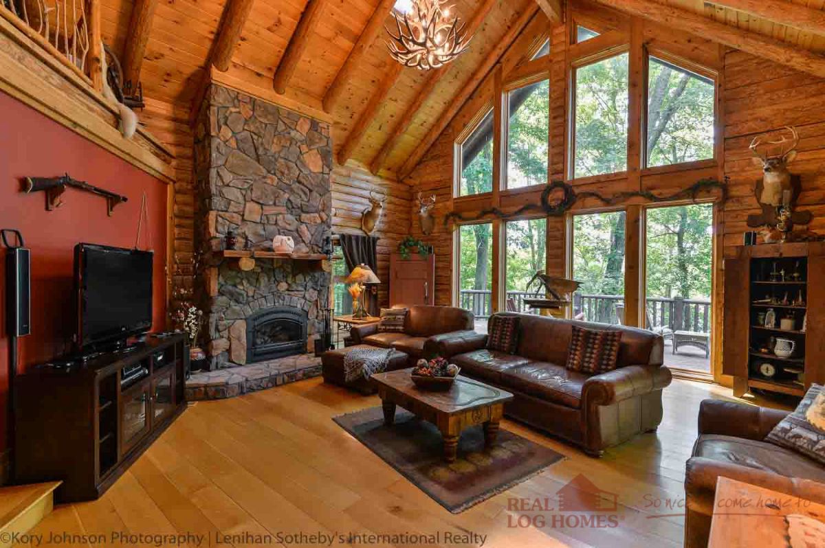 stone fireplace on left side of log cabin living room