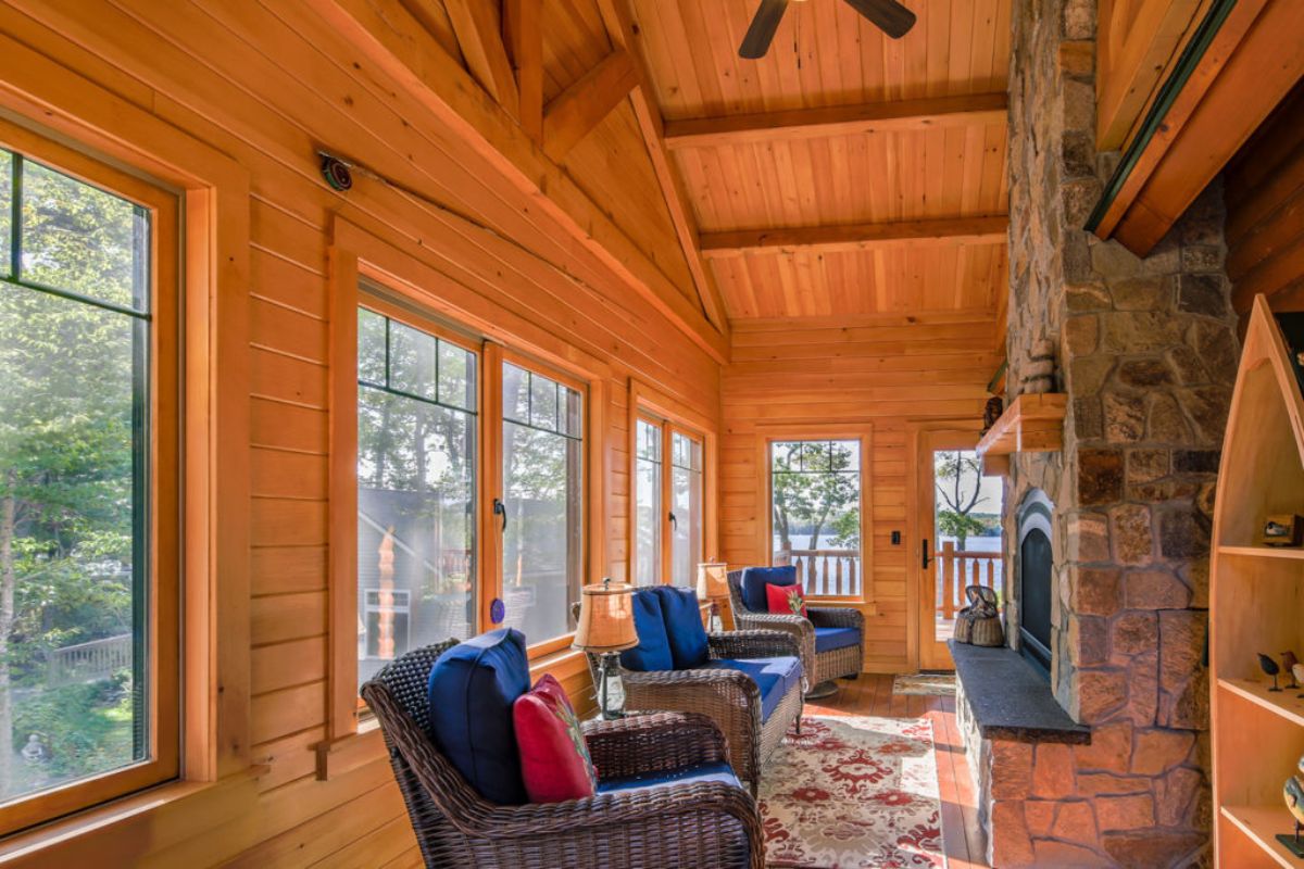 gray and blue chairs in front of fireplace with wall of windows in background