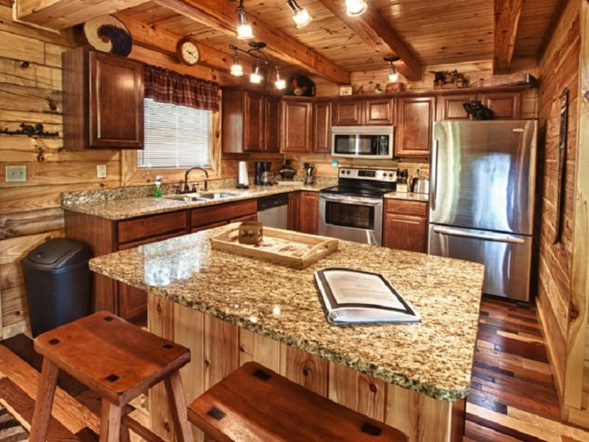 light granite countertops on island bar in log cabin kitchen