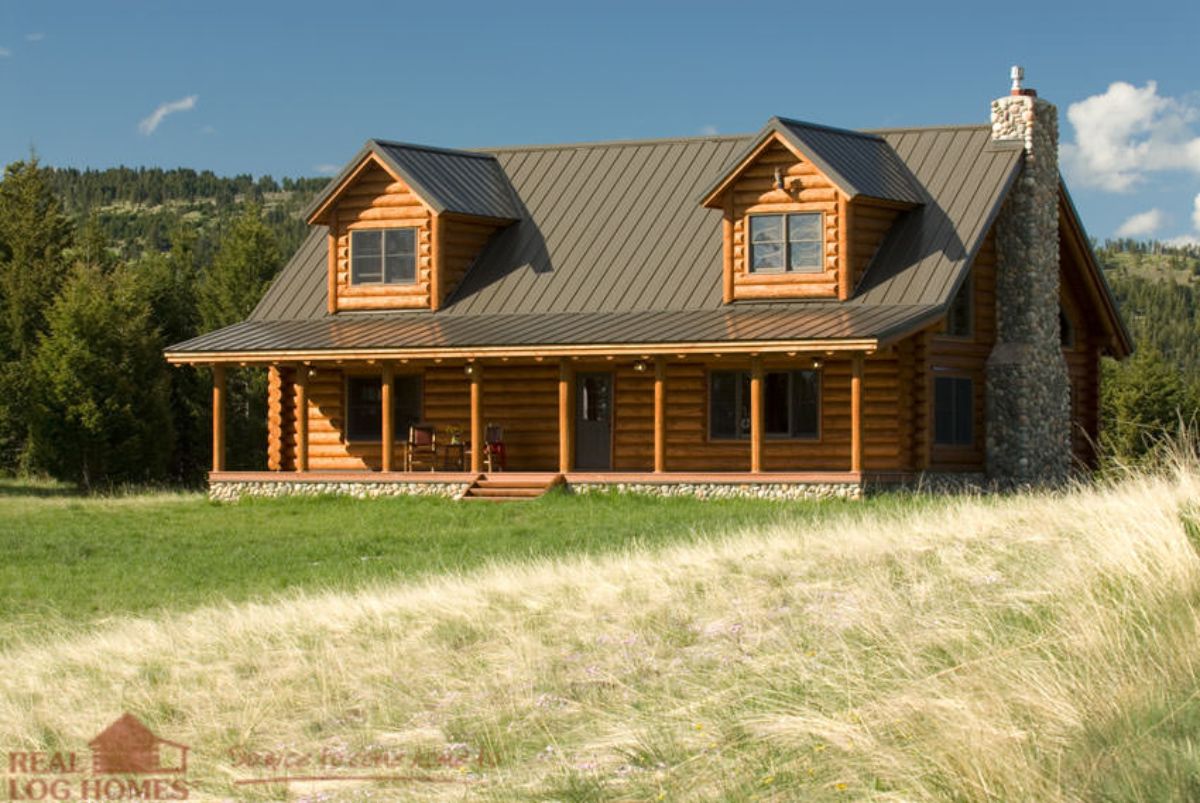 covered porch on front of log cabin with two dormer windows