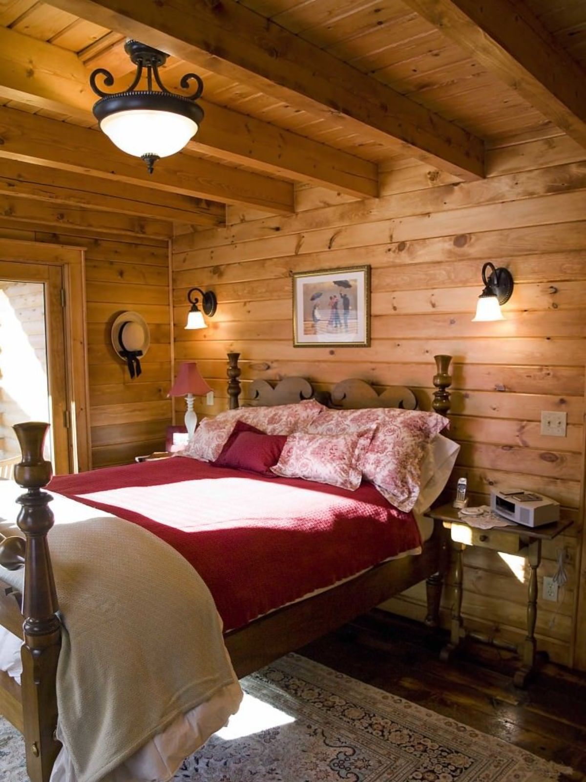 wood bedframe with maroon blanket against wood wall