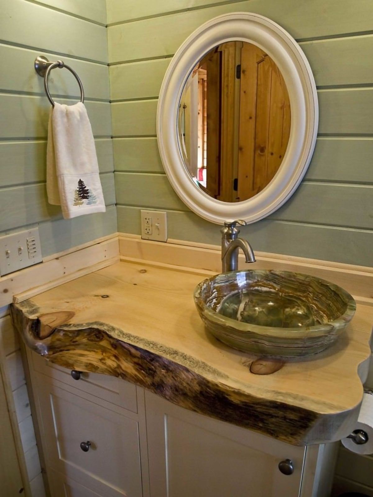 live edge wood counter in bathroom with green walls and bowl sink
