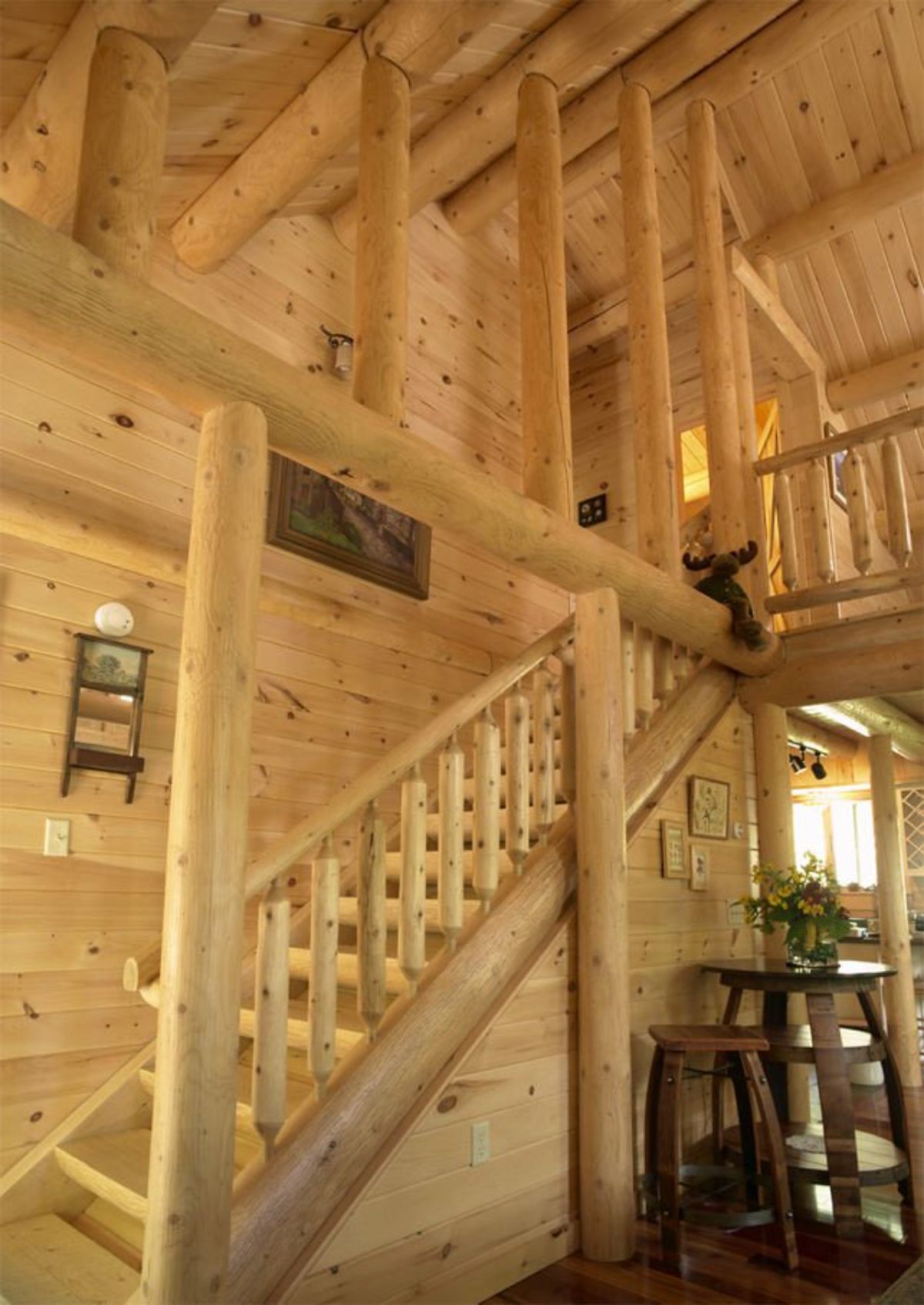 light wood staircase with exposed raw log beams