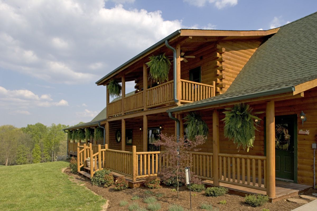 front porch with upper balcony and hanging pots on railing