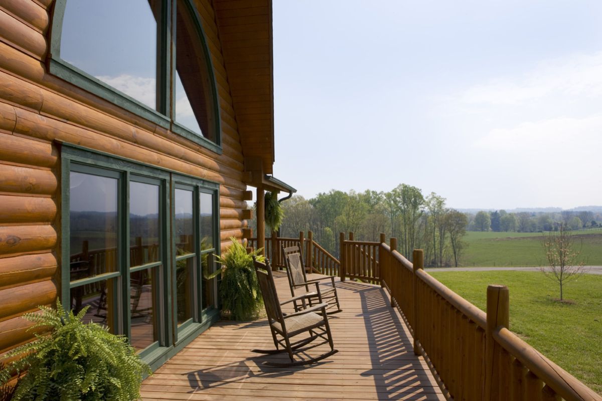 wall of doors and windows on left with open deck holding rocking chairs