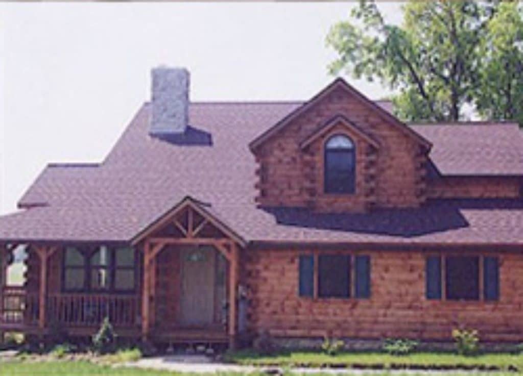 front of red wood log cabin with small porch