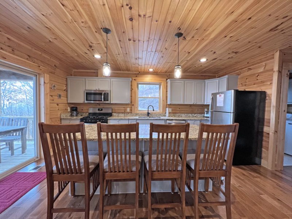 dark wood tall chairs against bar in kitchen with white cabinets