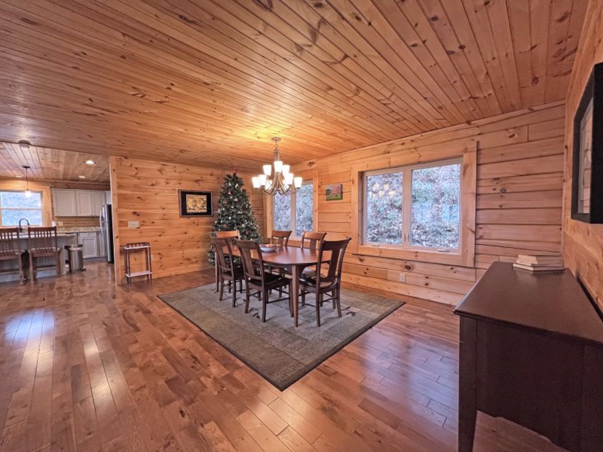 christmas tree in back corner behind dining room in log cabin
