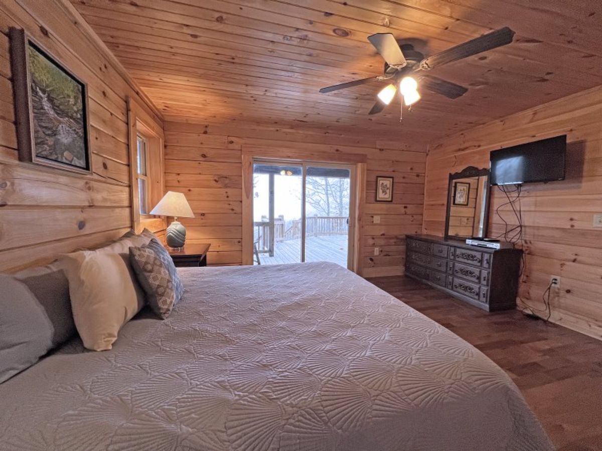 French doors on far wall of bedroom leading to deck