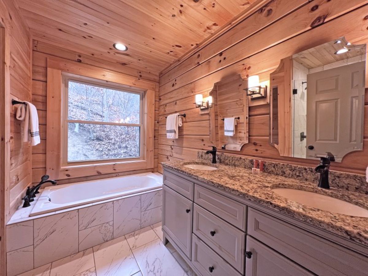 soaking tub in corner of master bedroom with granite countertop