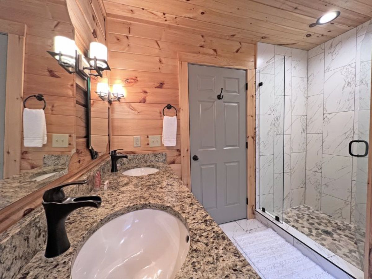 grey door next to open tiled shower in bathroom