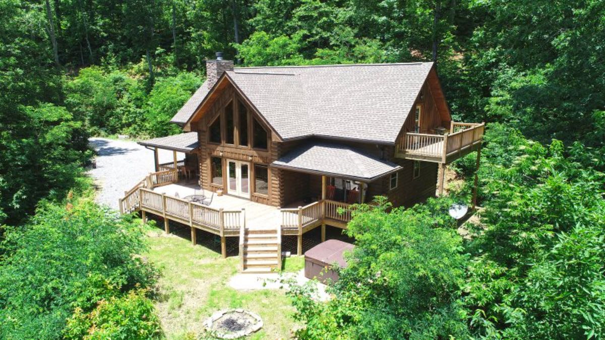 side of log cabin showing stairs off deck to property