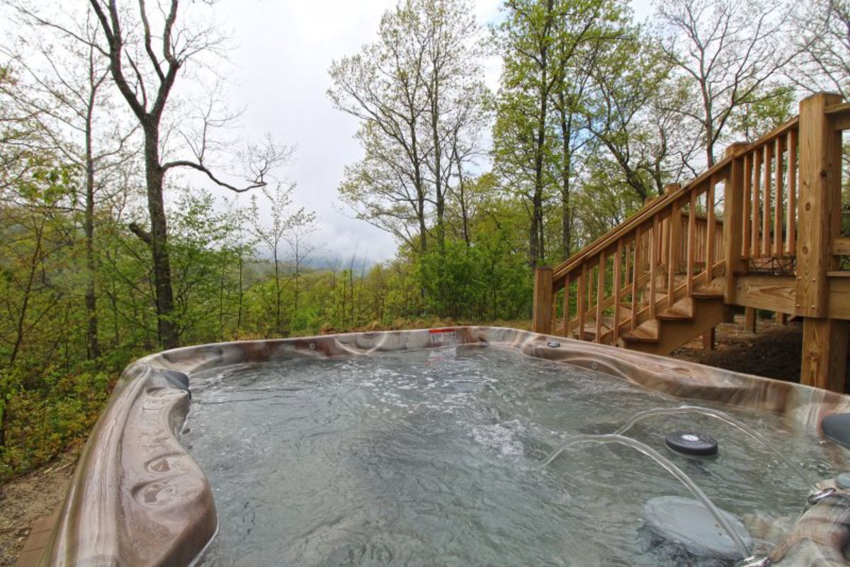 hot tub on deck of log cabin