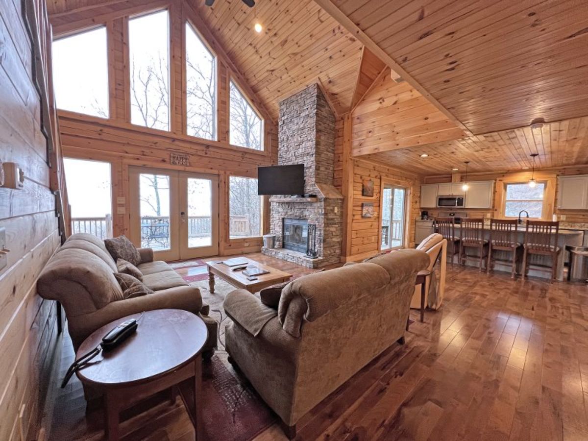 wall of windows on far left with chimney in the middle and kitchen to right