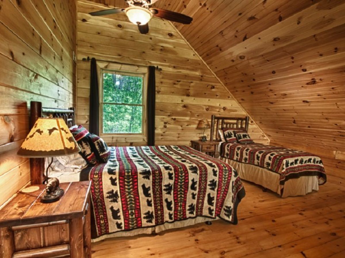 two beds in loft bedroom with ceiling fan