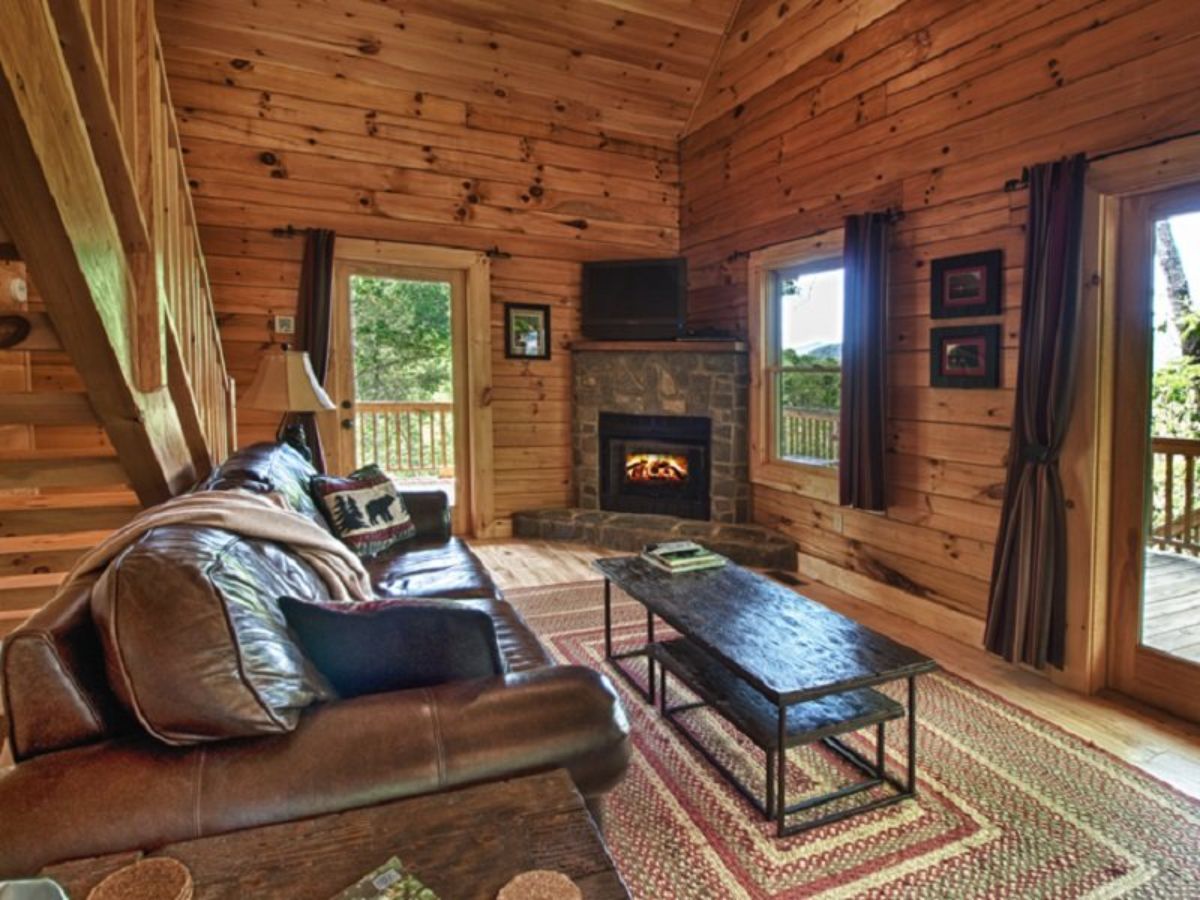 sofa against wall with black coffee table and corner stone fireplace