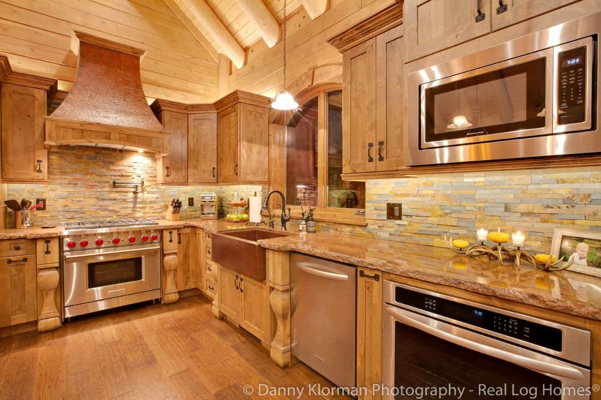stainless steel appliances against light wood cabinets in log cabin