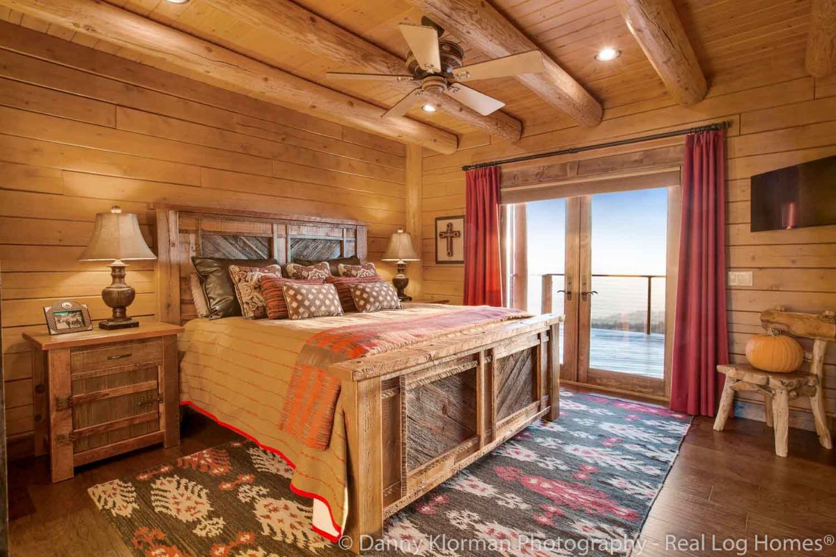 sliding doors with red curtains on back side of log cabin bedroom