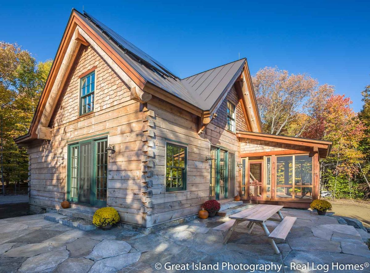 light wood exterior of log cabin with light teal accents at windows