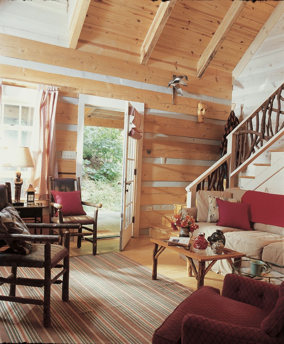 living room with door open on far wall and stairs to second floor on back right