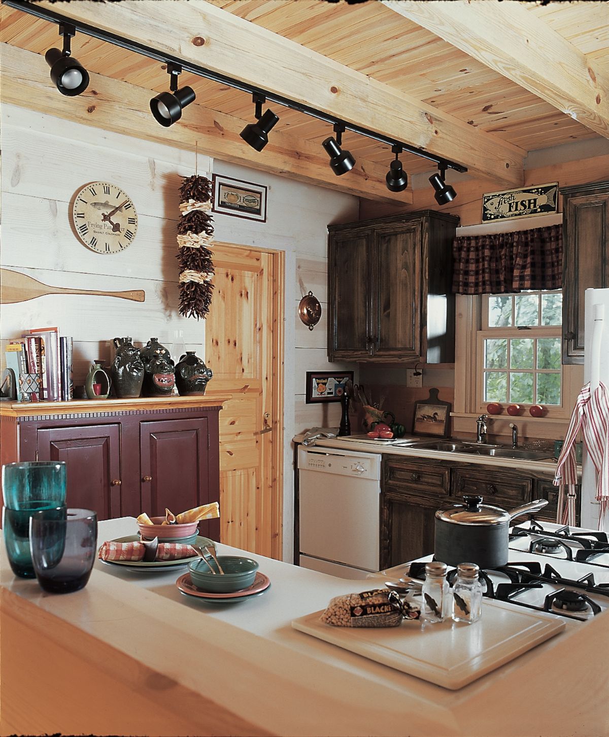 corner kitchen with dark wood cabinets and white appliances