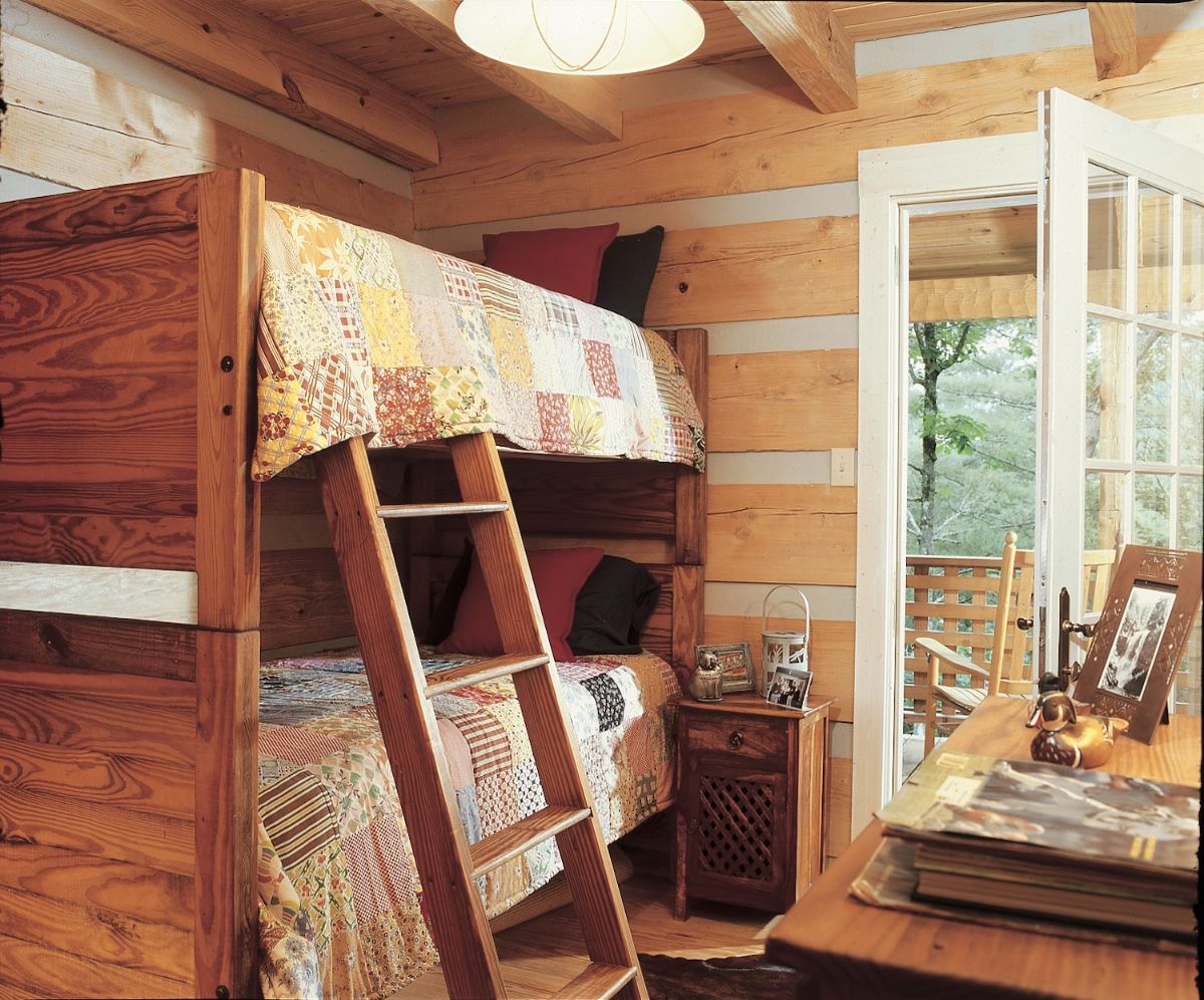 bun k beds against light wood and white chinking wall in log cabin