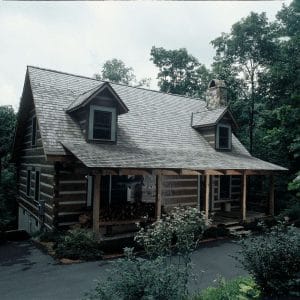 dark wood with white chinking on cabin with light shingles