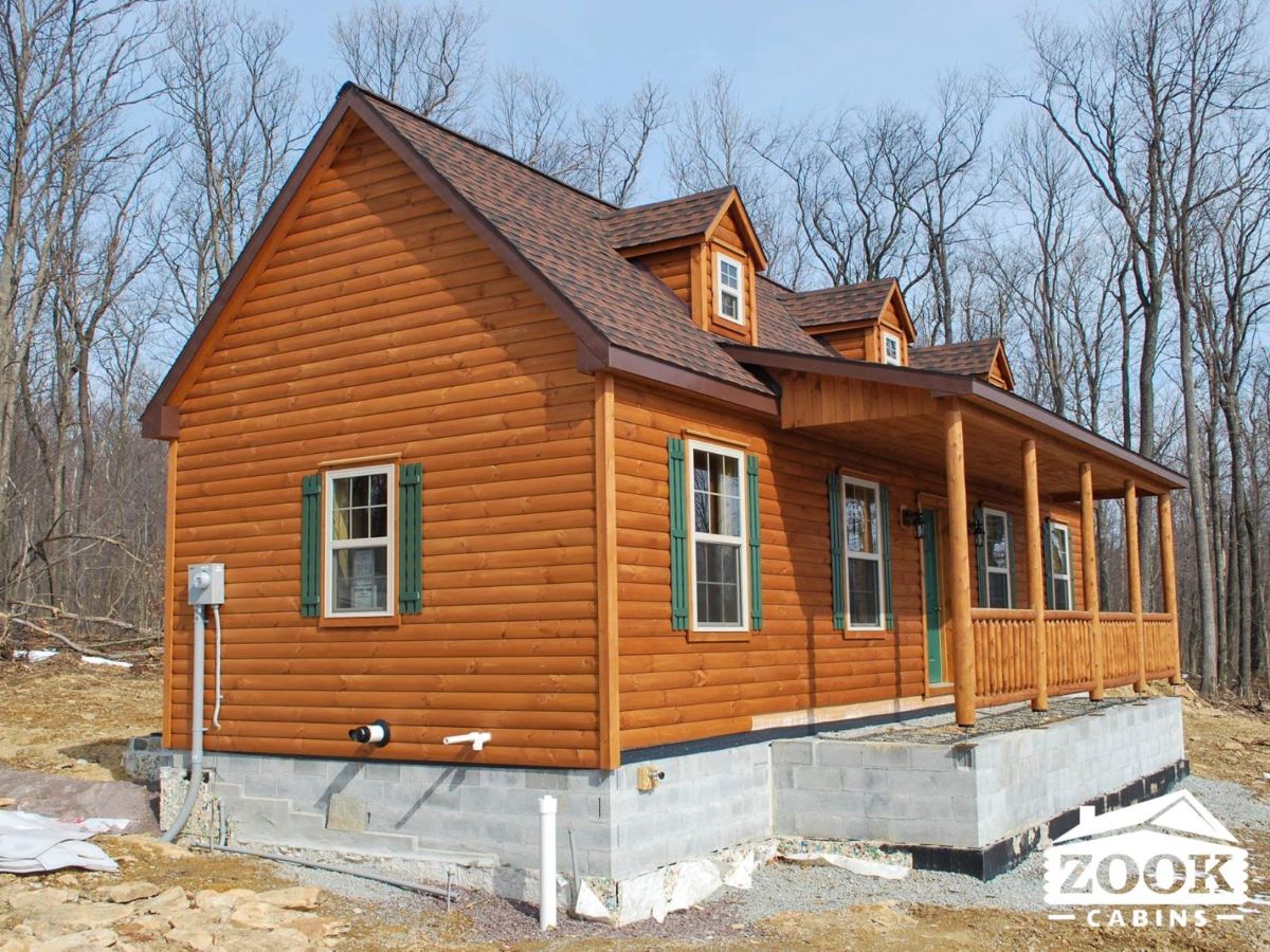 side of log cabin showing concrete foundation